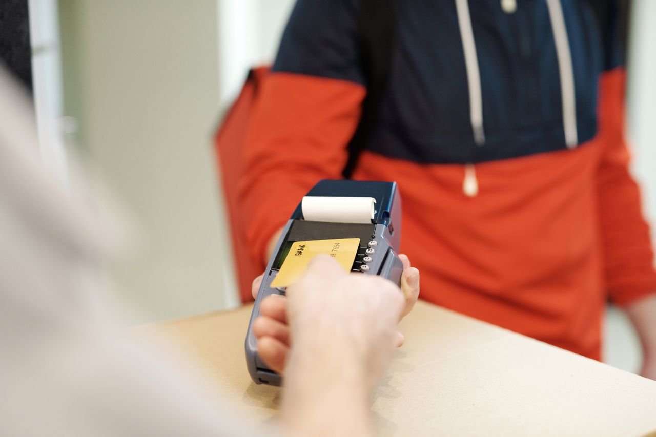 Home Close-up view of a contactless payment transaction using a credit card on a terminal device.