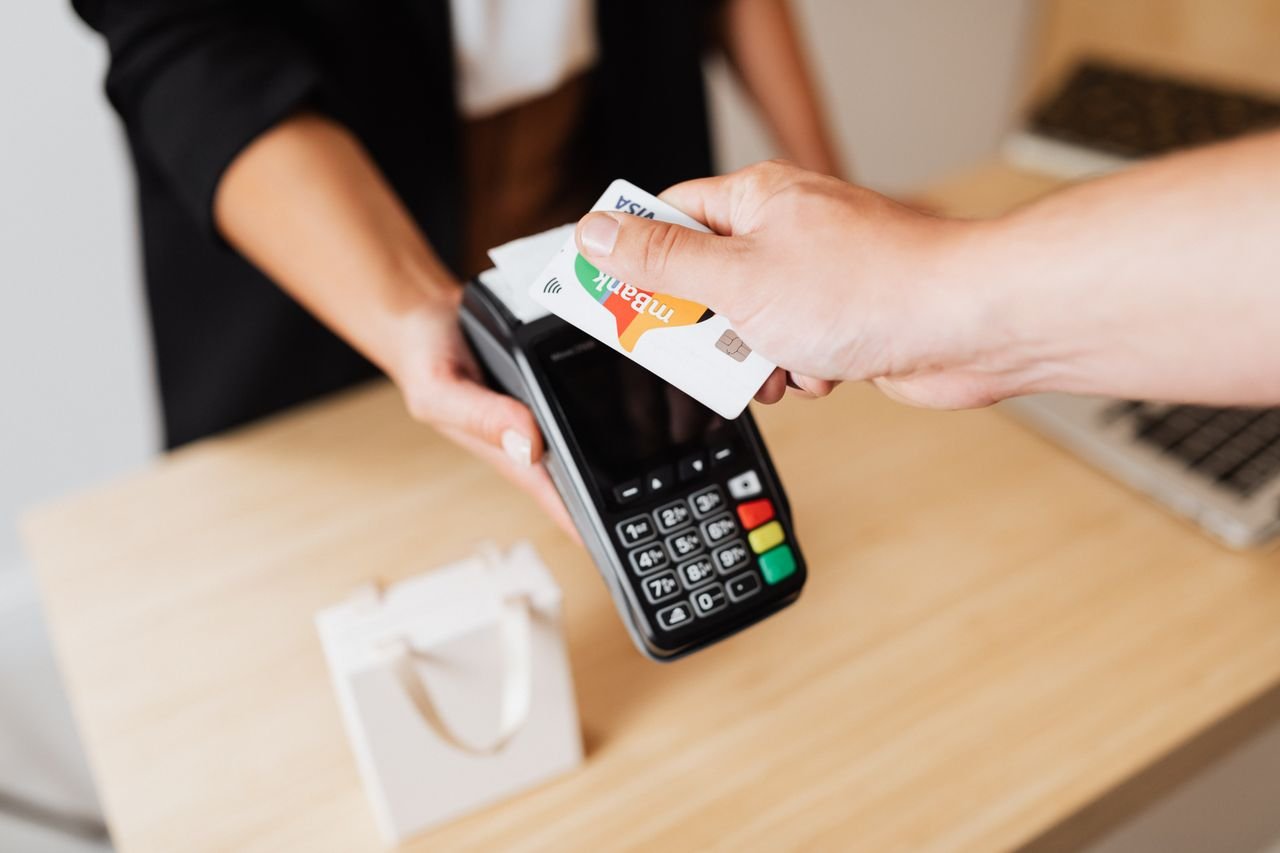 Home Close-up of contactless payment using a credit card at a modern POS terminal.